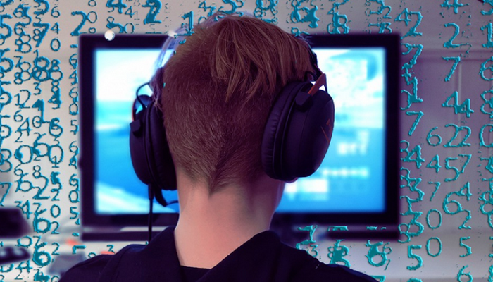 Streamer mit Kopfhörern vor einem Monitor